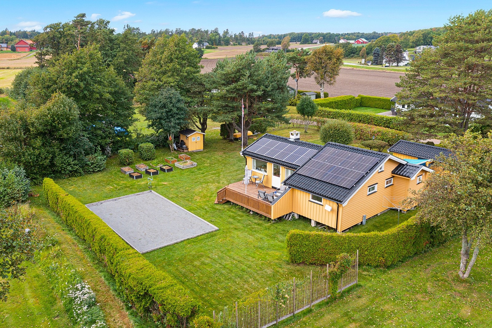 Det er en stor boulebane og rikelig plass til utendørs spill og aktiviteter Galleribilde