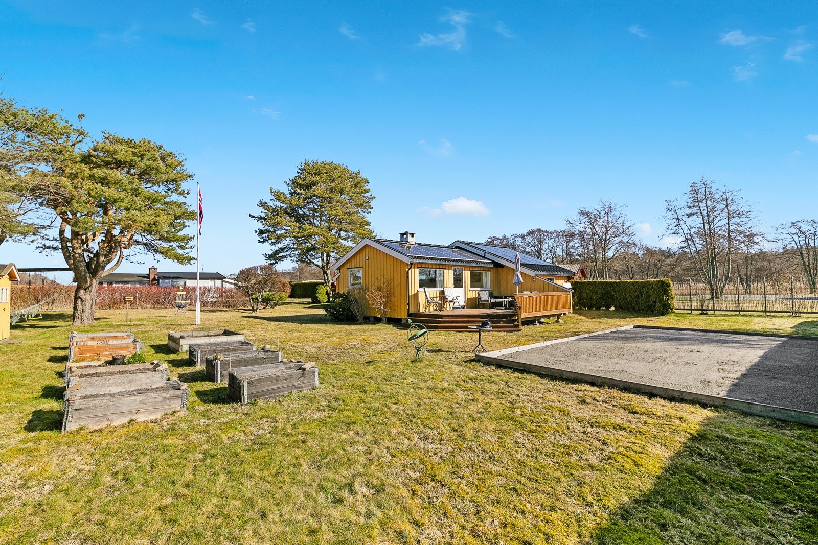 Fantastisk hage som er pent opparbeidet med blomster, busker og flere plantekasser Galleribilde