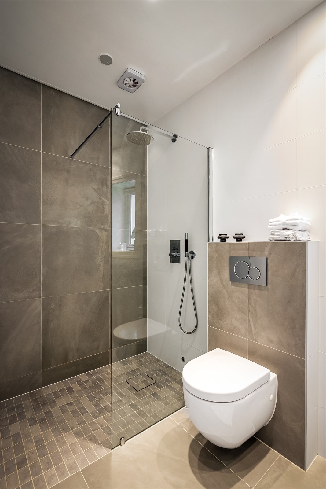 Badet har moderne og stilrene fliser, downlights i taket og elektriske varmekabler i gulvet. Galleribilde