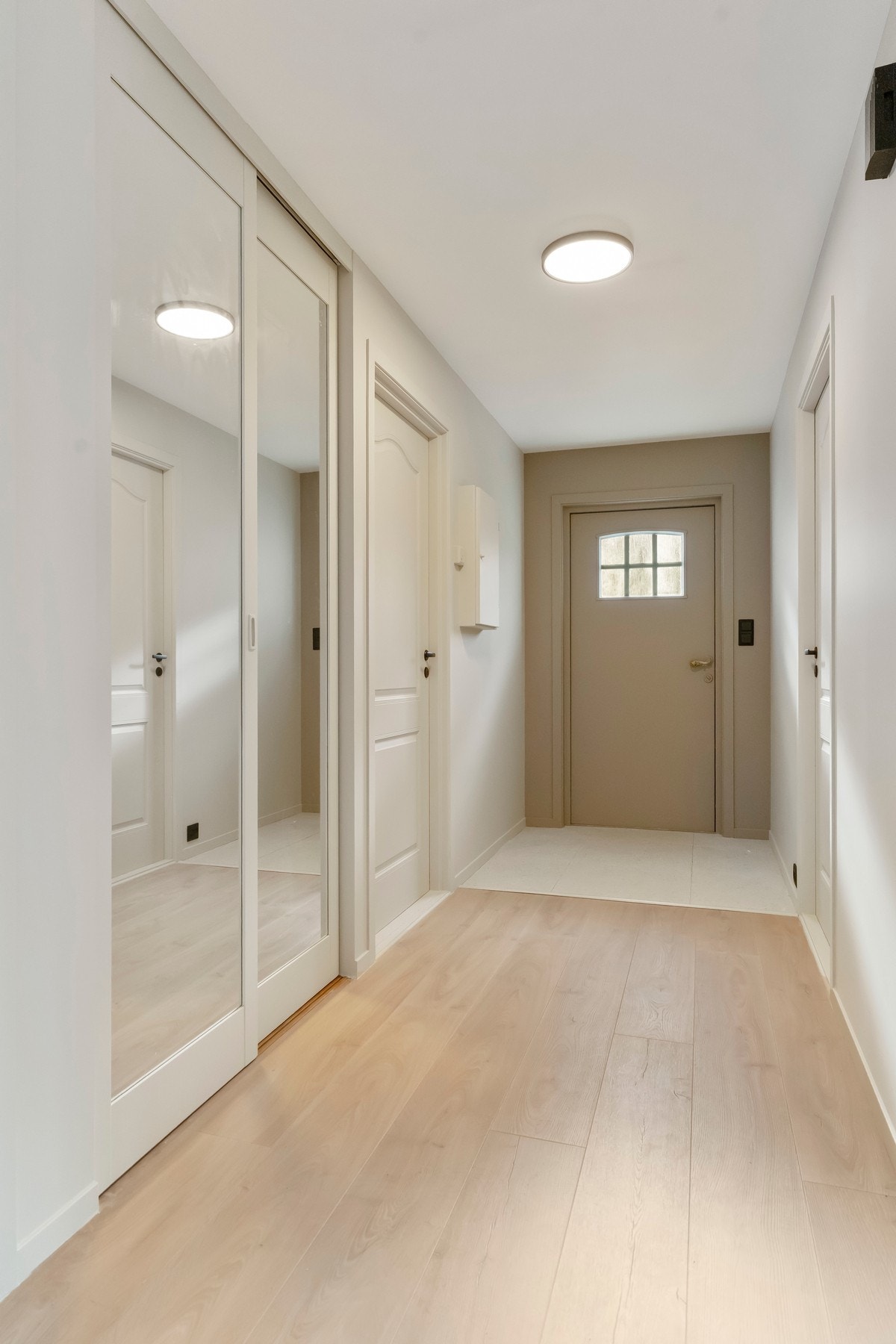 Romslig gang som har skyvedørsgarderobe med speildører. Plass til oppbevaring av yttertøy og sko. Flis på gulv i ytterste del av entrè. Galleribilde