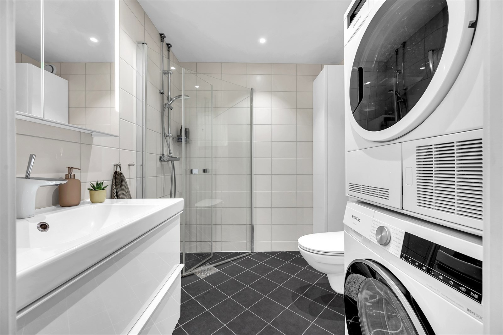 Pent, romslig bad som ble pusset opp i regi av borettslaget i 2018. Badet har flislagte overflater, innfelte downlights og elektrisk gulvvarme. Galleribilde