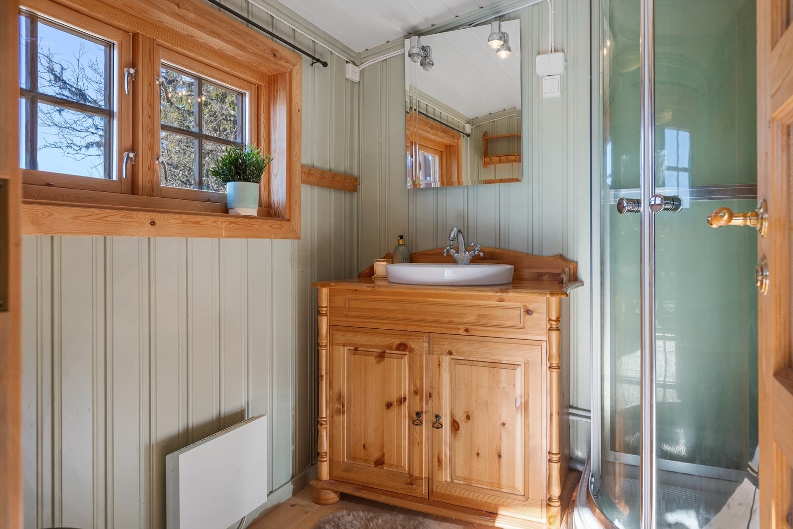 Sanitærrom med servant og dusjkabinett. Vann fra dunk med trykkpumpe. Såkalt Vera system i følge opplysninger i fra selger. Plass for skap for oppbevaring. Galleribilde