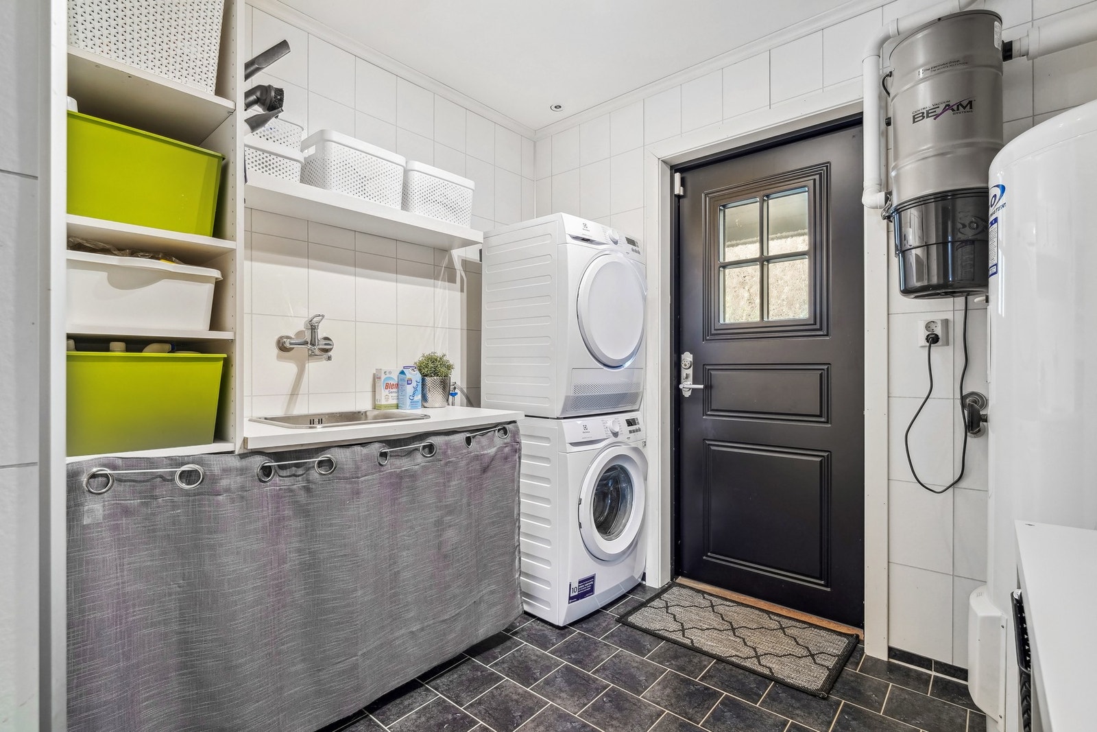 Vaskerommet har egen inngang, og standard er fra byggeår. Flislagt gulv med vannbåren gulvvarme og på veggene er det våtromsplater. Opplegg for vaskemaskin, tørketrommel og laminat benkeplate med stålskyllekum. Galleribilde