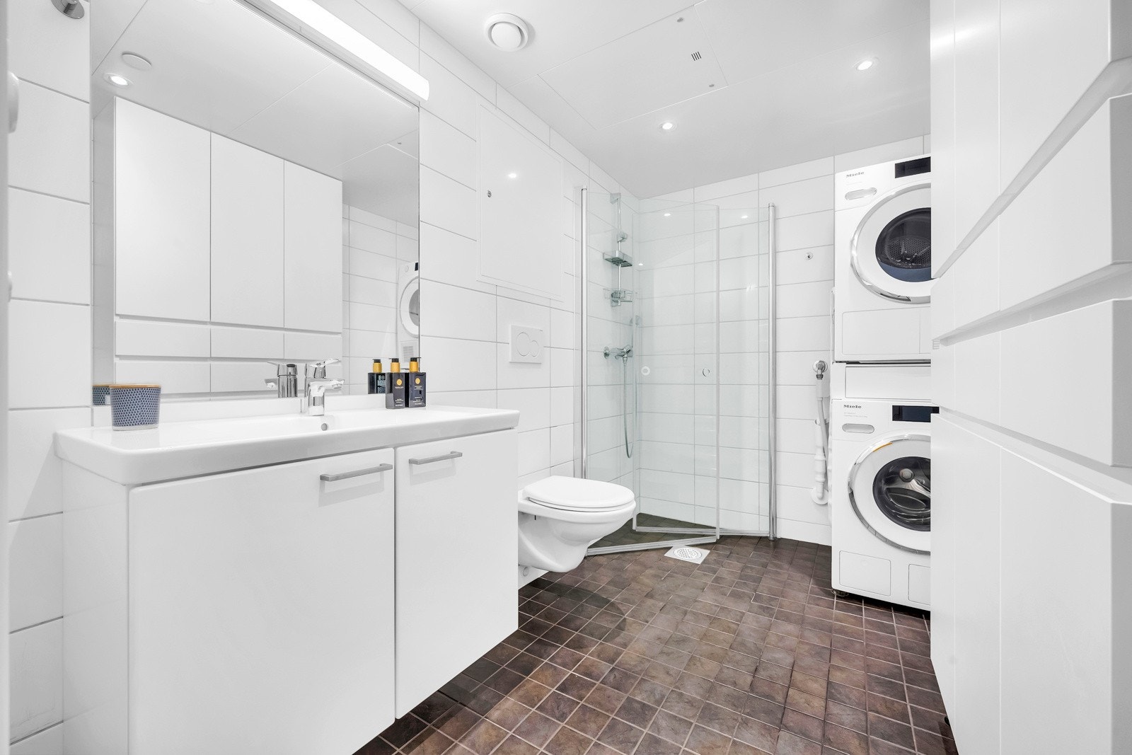 Bad/wc med veggmontert toalett og dusjnisje. Galleribilde