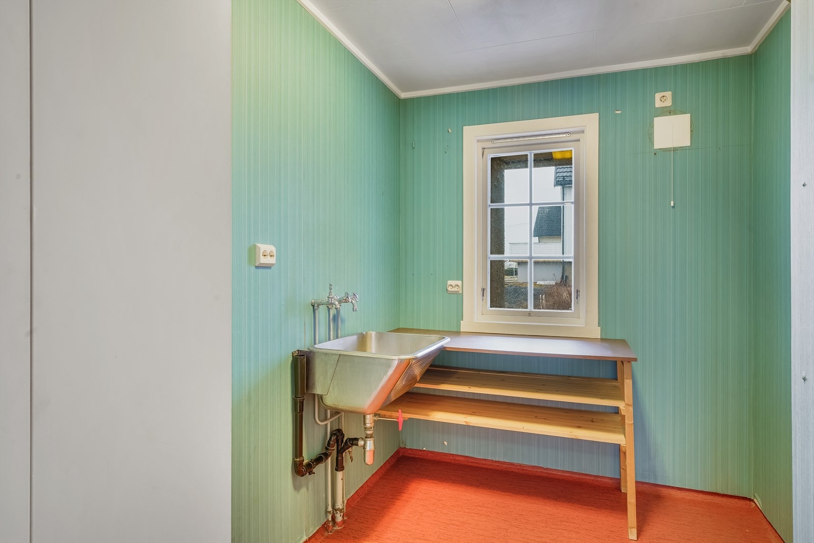 Vaskerommet har belegg på gulv, plastsluk og tapetserte vegger. Galleribilde