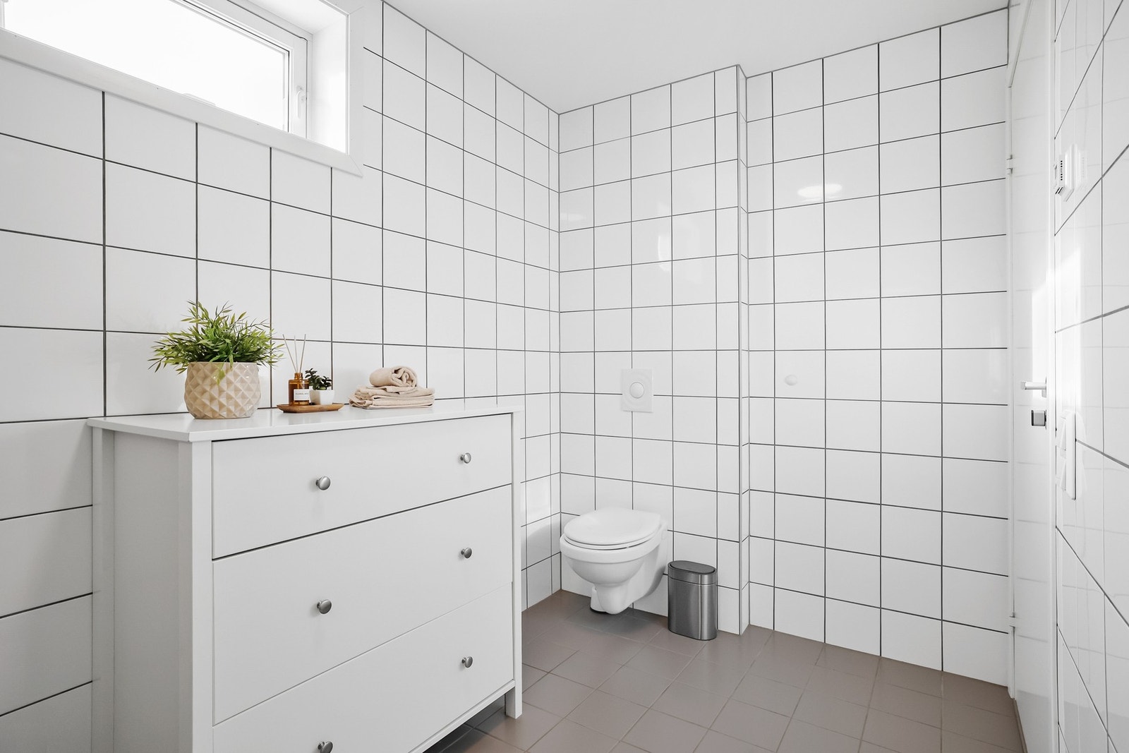 Badet har flislagte vegger og gulv. Galleribilde