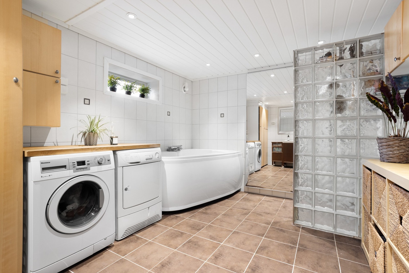 Bad Kjeller - Stort og romslig bad som er innredet med badekar, dusjnisje, toalett, baderomsinnredning med servant og vaskeromsinnredning med opplegg for vaskemaskin og tørketrommel. Galleribilde