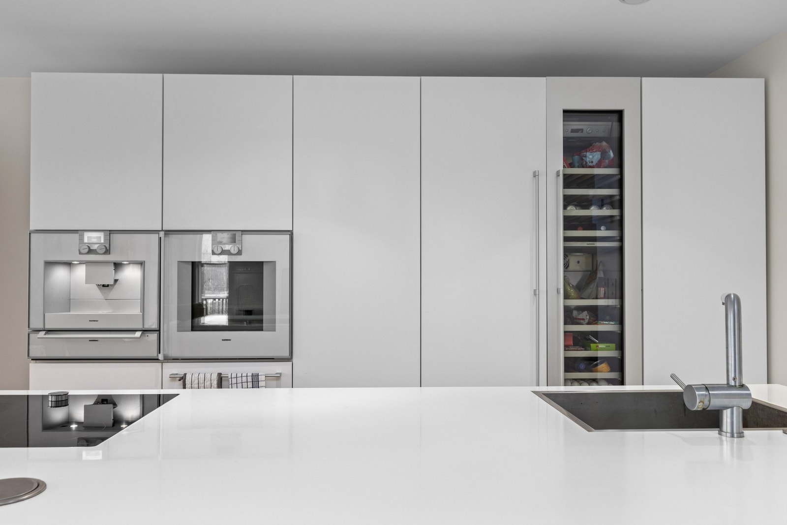 Eksklusivt kjøkken med corian benkeplate og nedfelte steketopp og vask. Galleribilde