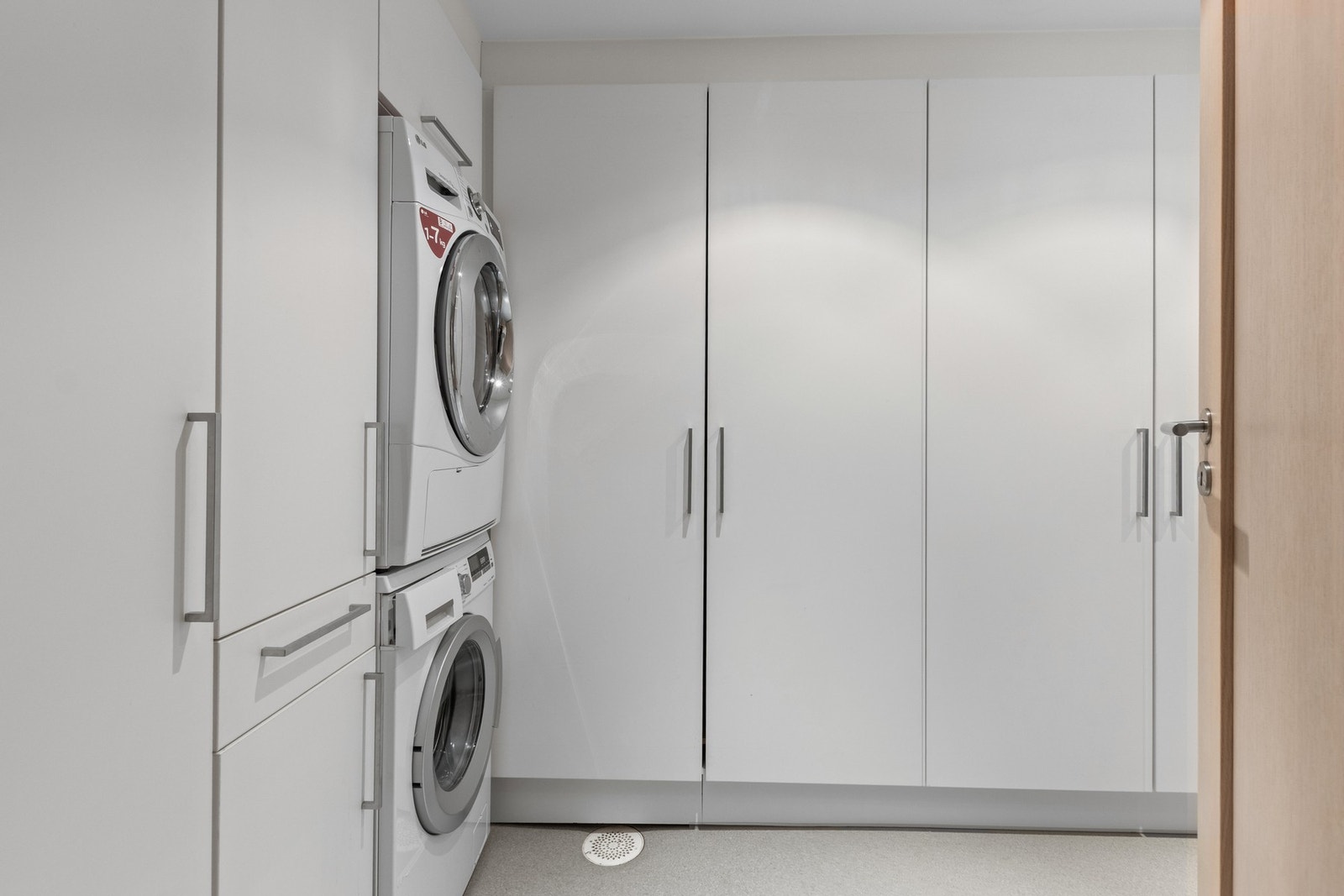 Vaskerom med mye lagringsplass. Romslig innredning med innebygd strykebrett. Galleribilde