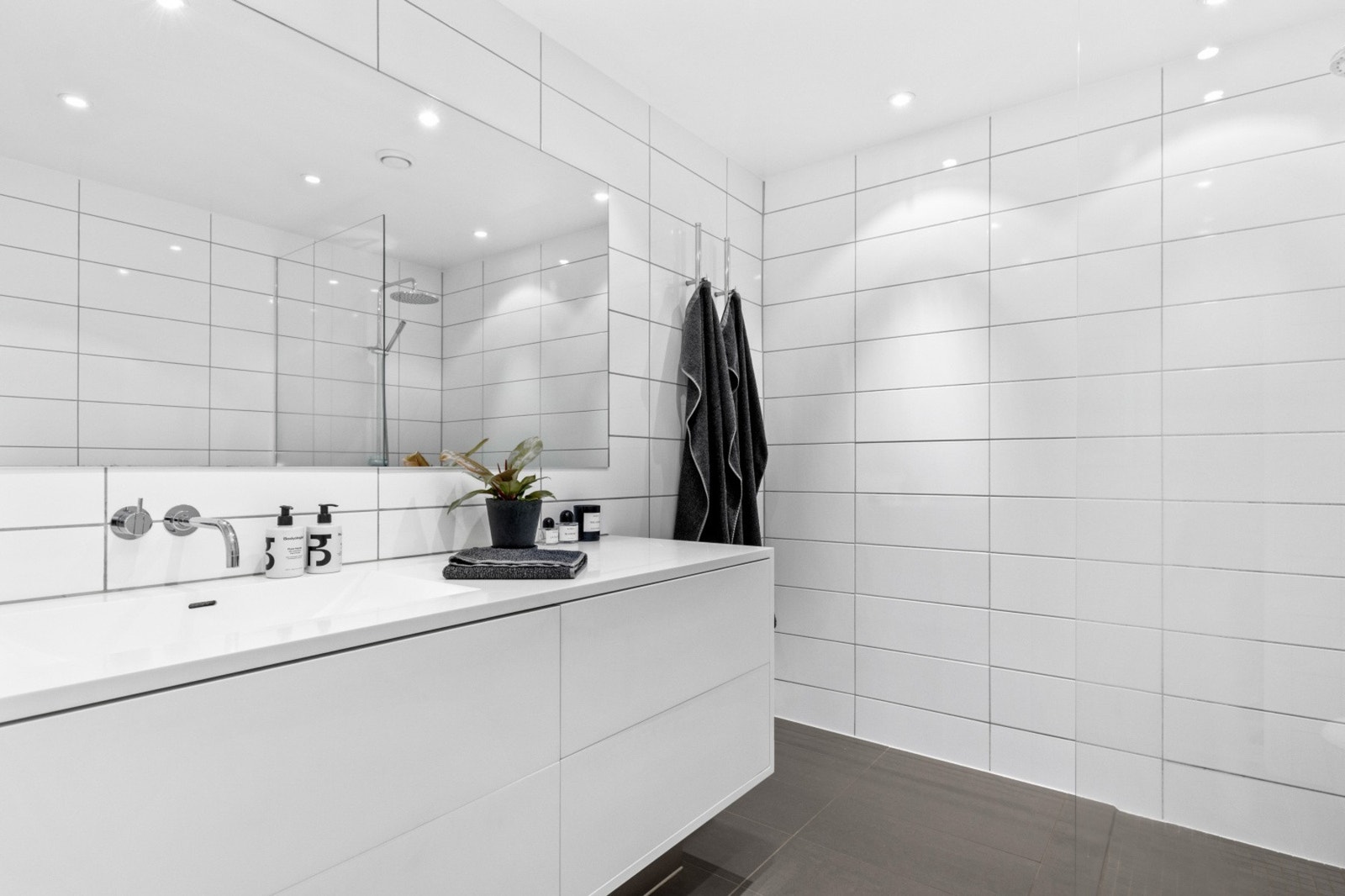 Innfelte spotlights i tak. Godt med lagringsplass i baderomsinnredningen. Corian vask og benkeplate. Galleribilde