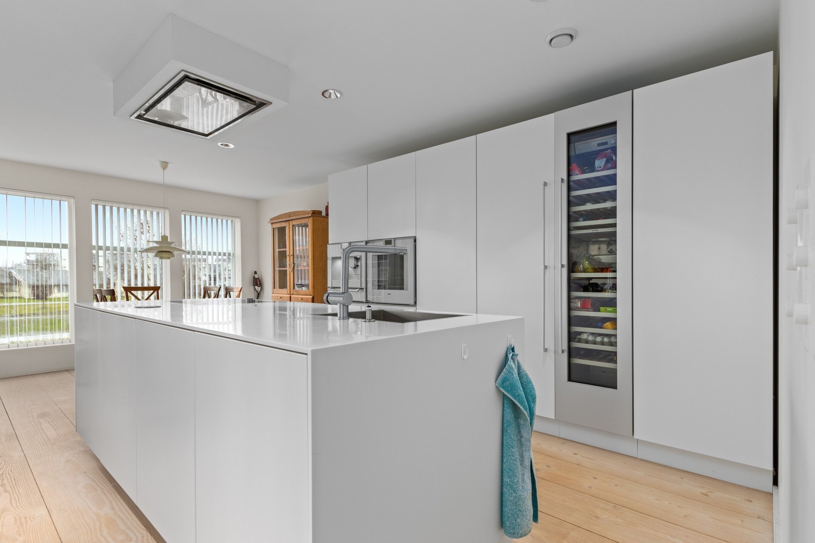 Mutliform kjøkken med innebygde Gaggenau hvitevarer. Stort vinskap også installert. Galleribilde