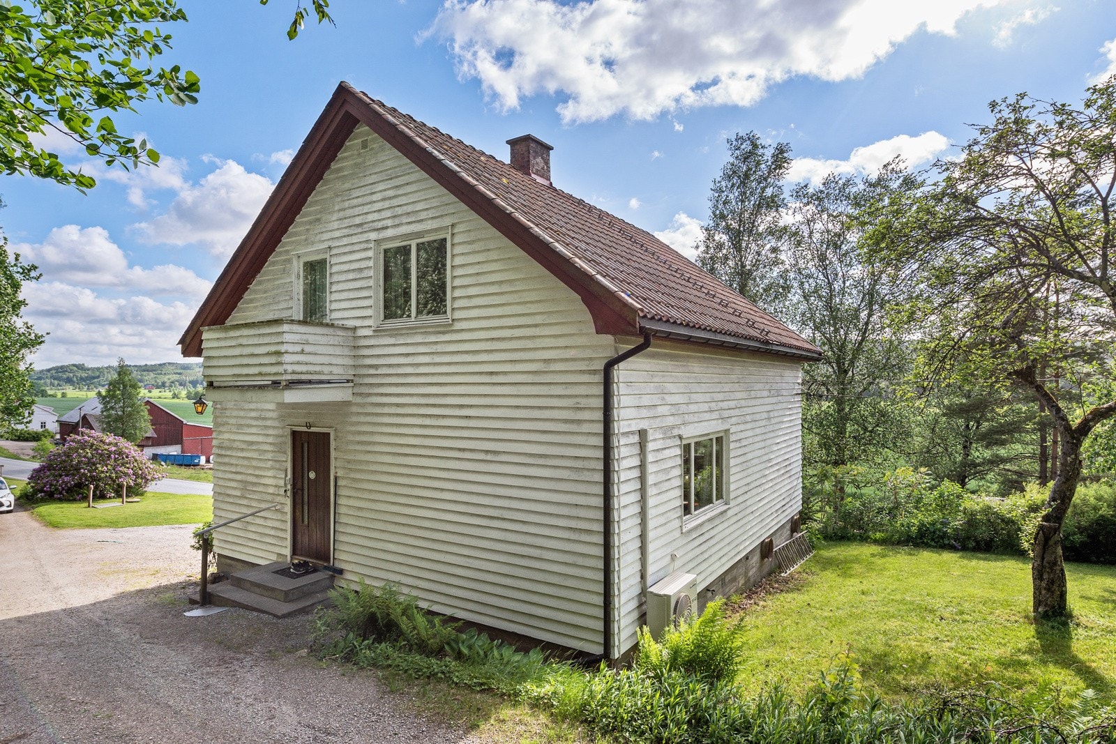 Tomten er opparbeidet med gressplen, prydbusker, frukttrær og trær Galleribilde