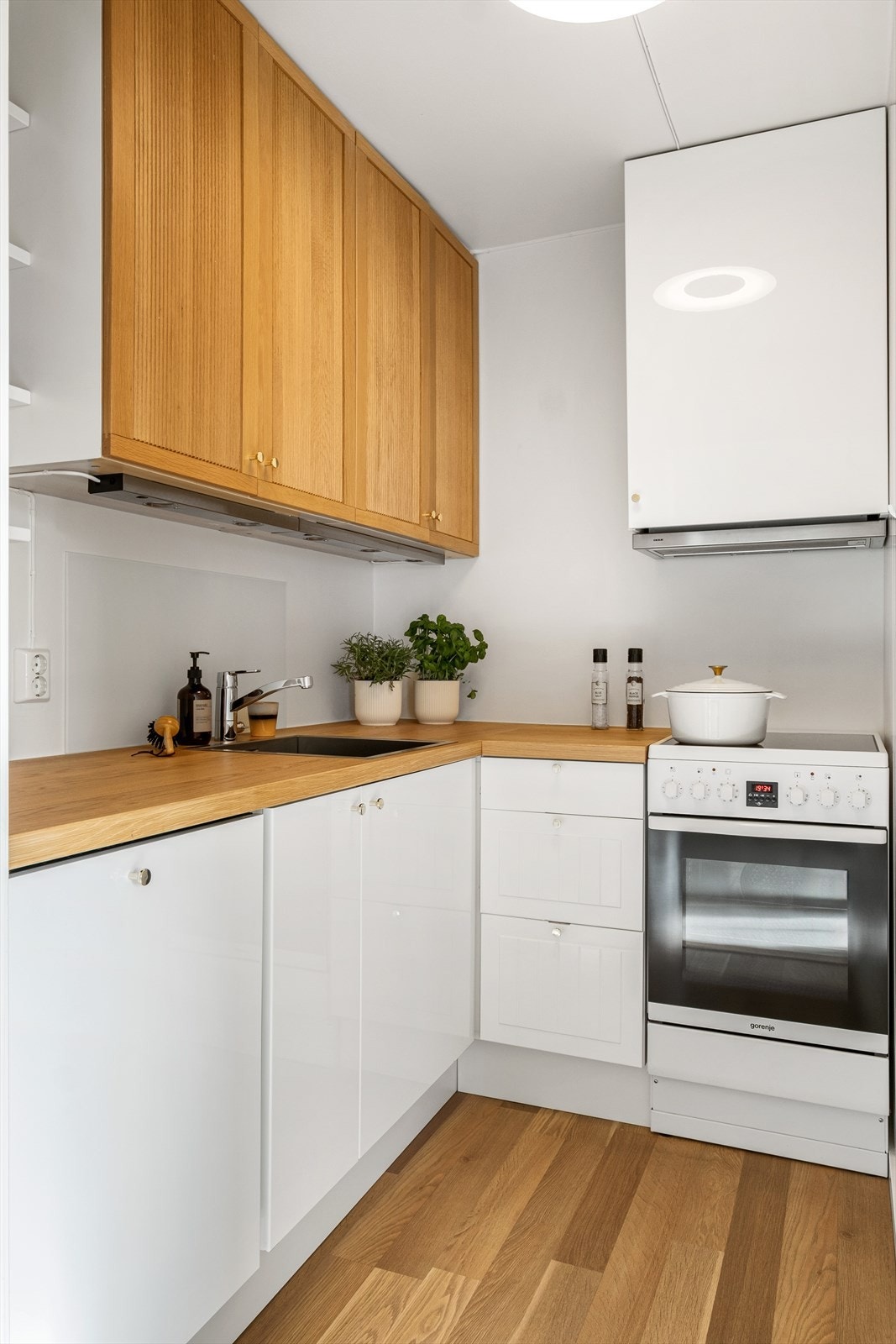 Kjøkkeninnredning med laminerte benkeplater, plateslått/malt backsplash, profilerte fronter og ventilator med utkast til ventilasjonssjakt. Frittstående hvitevarer og integrert oppvaskmaskin medfølger. Galleribilde