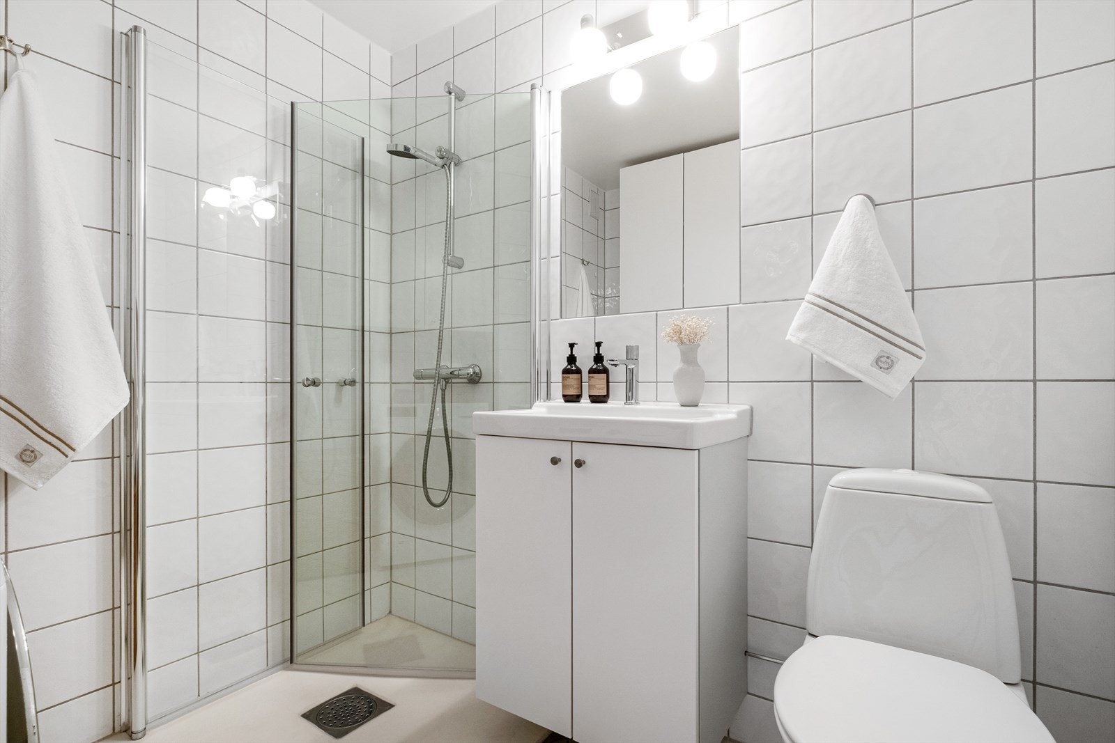 Stilrent bad med fliselagte vegger og microsement på gulv(lagt i 2025). Badet er utstyrt med wc, servant i innredning og opplegg for vaskemaskin. Galleribilde