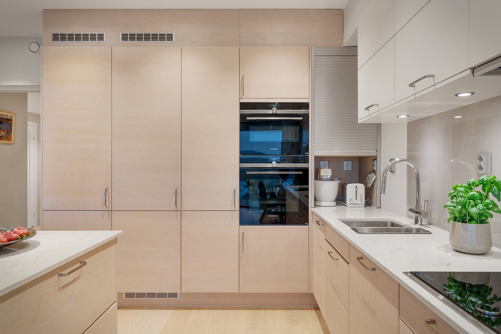 Påkostet kjøkken med hvitevarer av høy kvalitet og steinkompositt benkeplate. Galleribilde