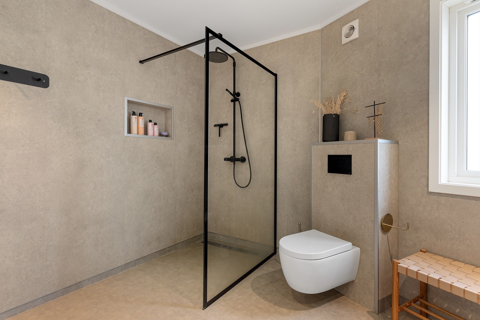 Rommet er utstyrt med downlights, vegghengt toalett, innredning med nedfelt servnat, dusjhjørne og varmekabler i golv. Galleribilde