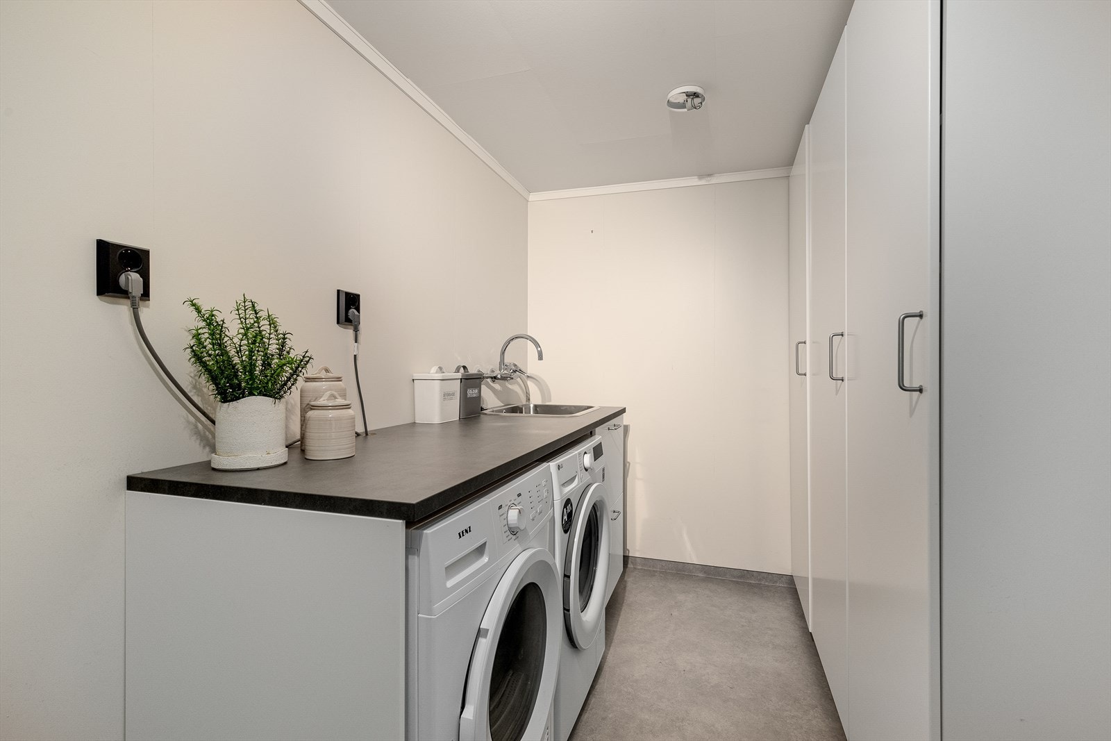 Vaskerommet har våtromsbelegg på golv, malte sponplater på veggar og malte himlingsplater med downlights. Vaskerommet har fin innredning med opplegg for vaskemaskin, plass til tørketrommel og nedfelt vask. Galleribilde
