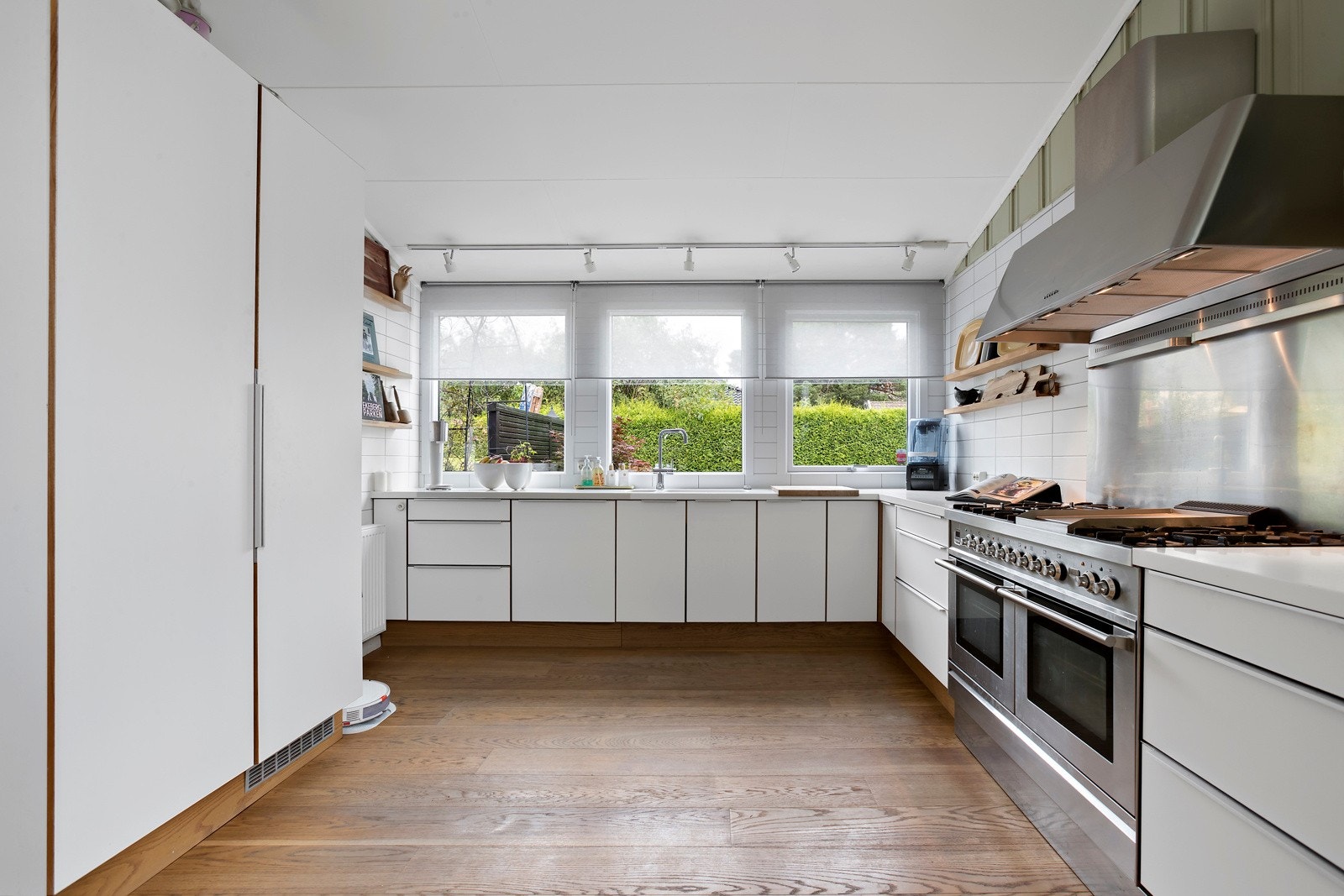 HTH kjøkken med corian benkeplate, integrerte hvitevarer og godt med lagringsplass i innredningen. Galleribilde