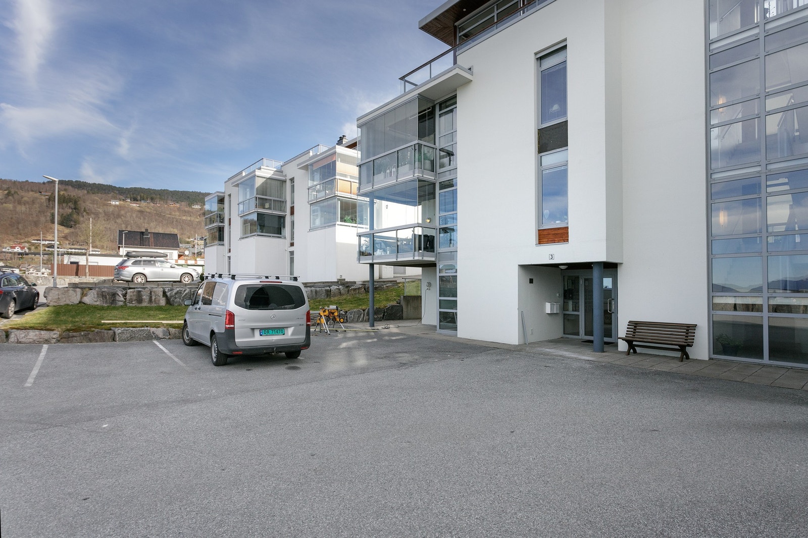 Hovedinngang og gjesteparkering. Leiligheten har egen parkeringsplass i felles garasje. Heis fra parkering til leiligheten. Galleribilde