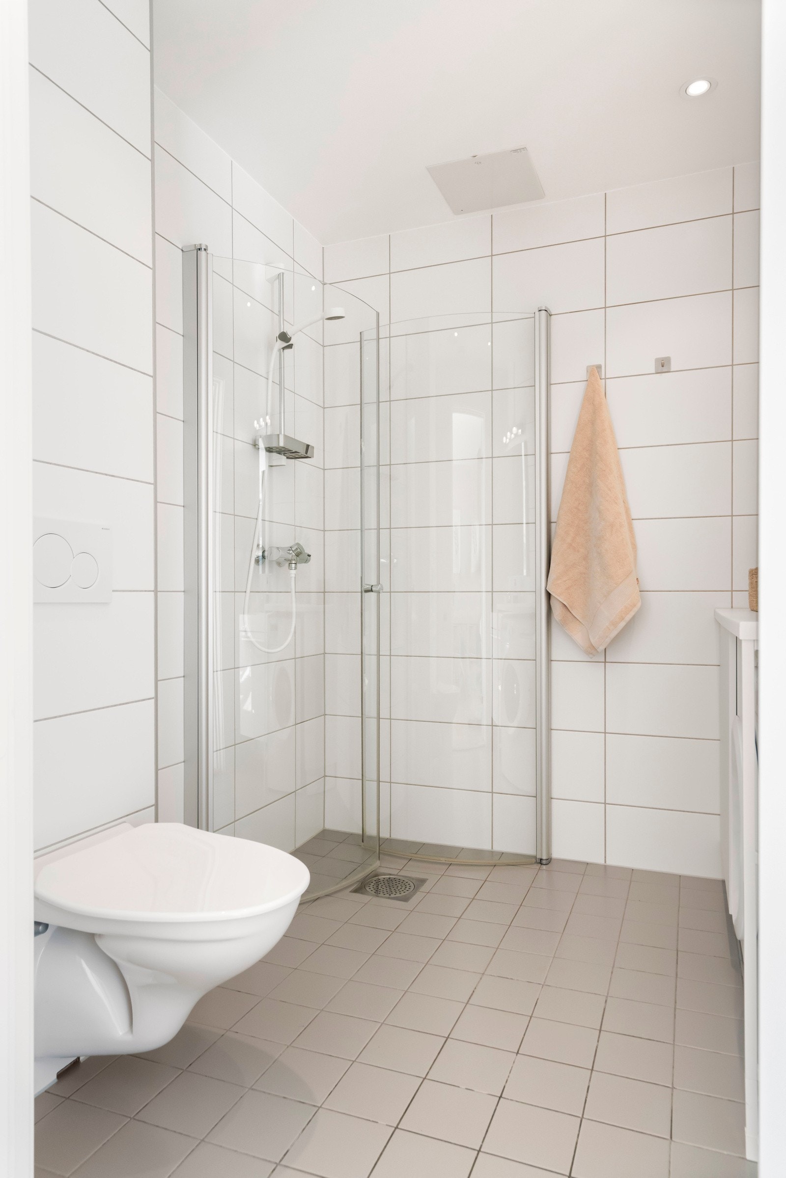 Baderomsinnredningen byr på servantskap med glatte, høyglans fronter og heldekkende servant. Speil med lysarmatur over på vegg over servant, dusjhjørne og toalett. Galleribilde