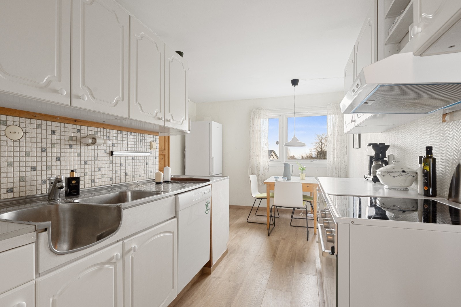 Et lyst kjøkken med gode oppbevaringsmuligheter og rikelig med benkeplass. Galleribilde