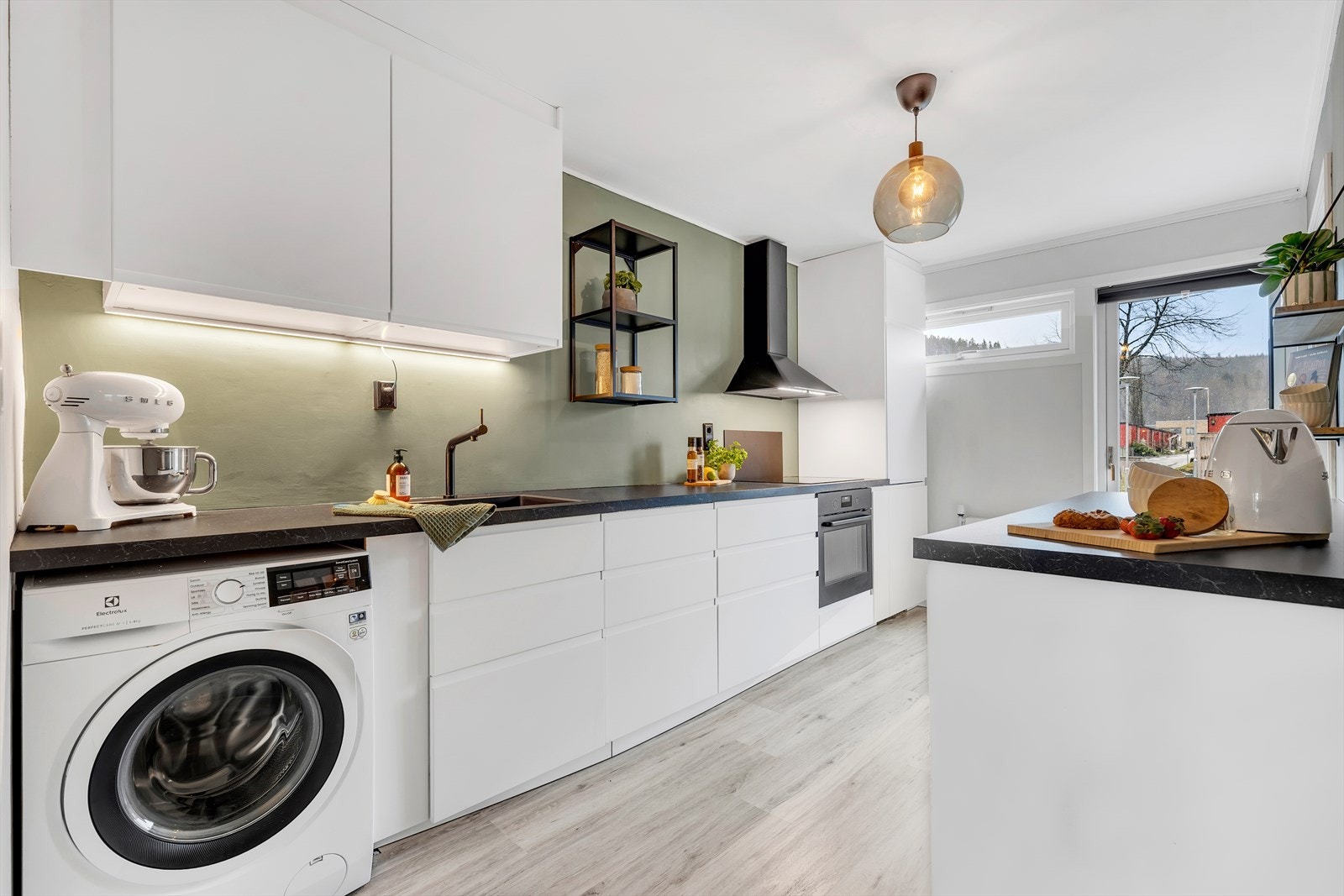 Innredning med mekanisk avtrekksvifte over stekesonen. Det er integrert stekovn, platetopp og oppvaskmaskin. Galleribilde