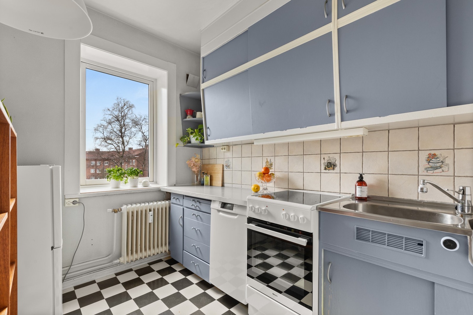 Praktisk spisekjøkken på eget rom med plassbygget original kjøkkeninnredning. Galleribilde