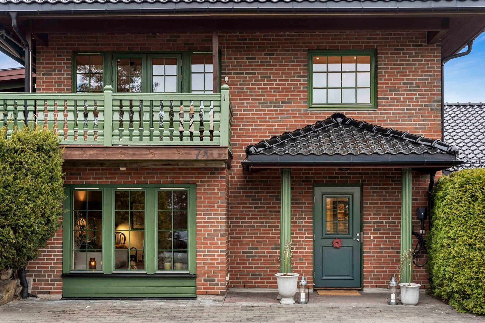 Koselig og pent opparbeidet inngangsparti med beleggningsstein. Elbillader er installert på yttervegg Galleribilde