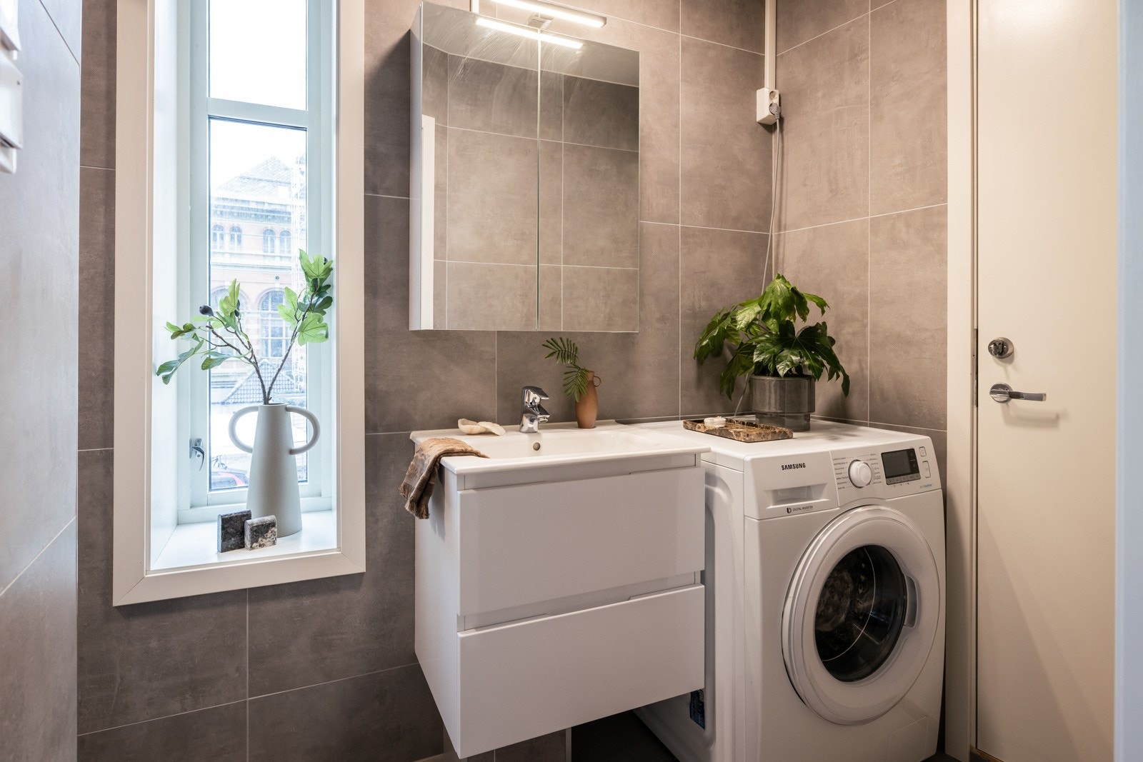 Badet har god størrelse og er helfliset i tidsnøytrale farger. Stilren innredning og oppvaskmaskin (som medfølger). Galleribilde