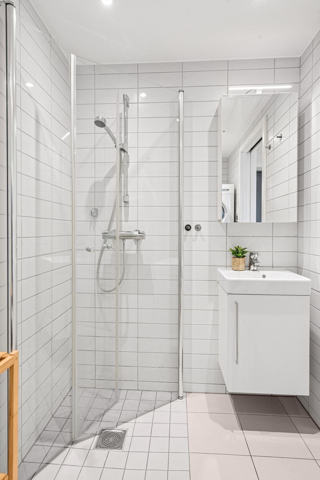 Badet er videre utstyrt med dusjhjørne, vegghengt toalett, servantskap og speilskap med oppbevaringsplass. Galleribilde