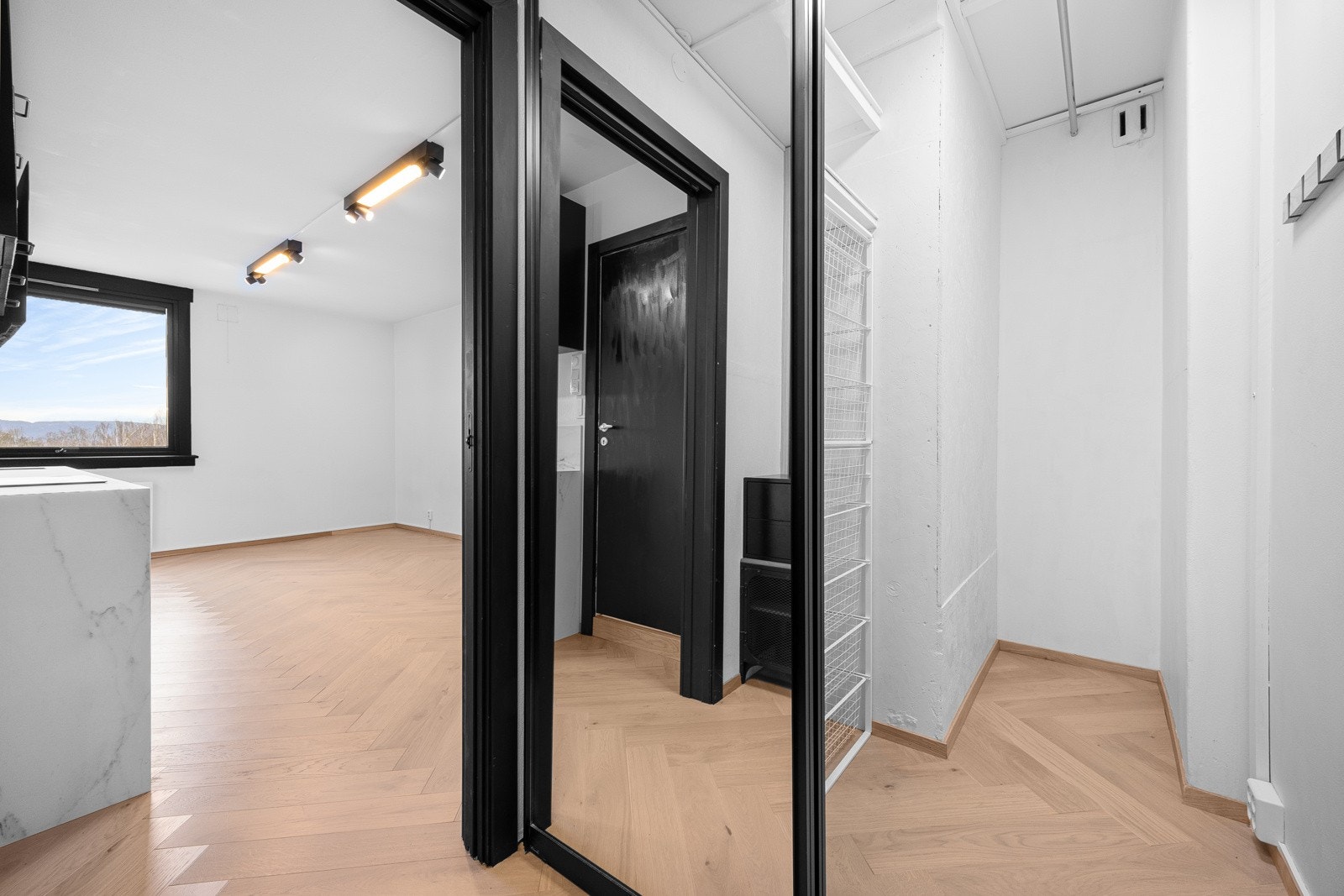 Inngang til innvendig bod hvor det er rikelig med plass til oppheng av yttertøy og det du ikke ønsker skal stå fremme. Galleribilde