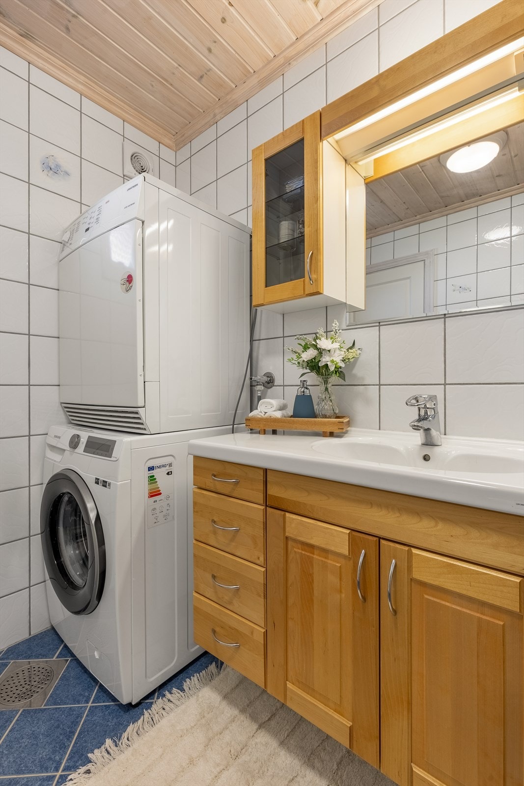 Badet er innredet med servantinnredning, opplegg for vaskemaskin, dusjkabinett og toalett Galleribilde