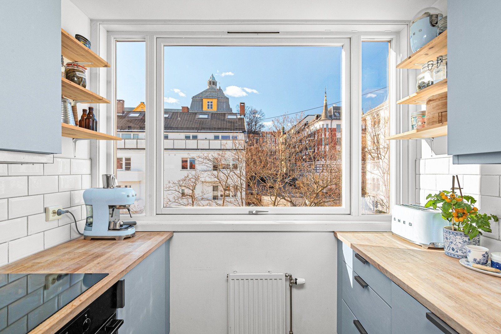 Kjøkkenet er utstyrt med integrerte hvitevarer og har et stort vindu ut mot frodig gårdsrom. Galleribilde