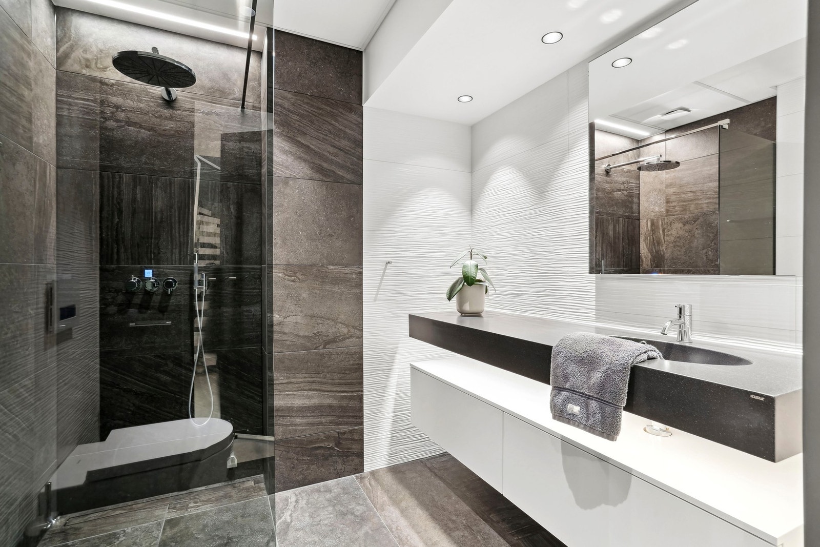 Leiligheten har to rålekre bad. og et vaskerom. Badet i 3.etasje har helstøpt servant som flyter over en skuffeseksjon med hvit front og skjult belysning. Galleribilde