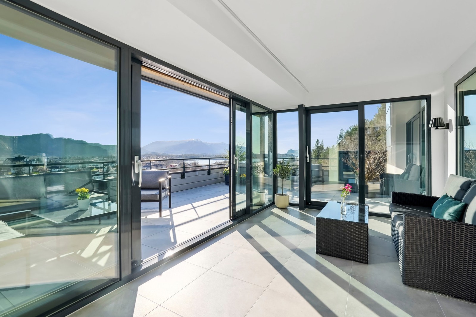 Den innglassede terrassen fungerer som et ekstra rom året rundt, med panoramavinduer og varmekabler i gulvet. Galleribilde