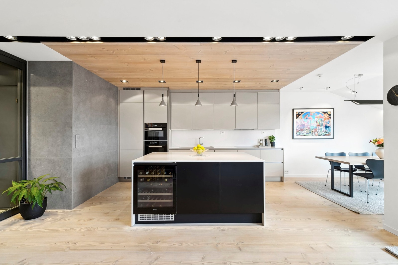 Den store øya med corestone og sorte fronter markerer overgangen til stuen, både visuelt og funksjonelt. Galleribilde