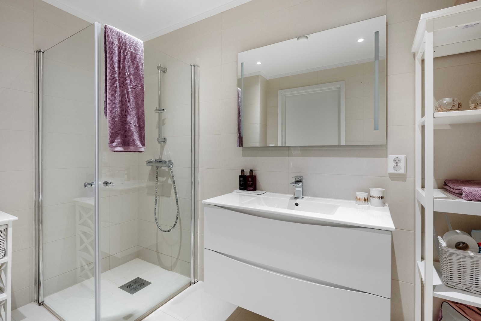 Badet er moderne og stilrent med lyse, delikate fliser på vegger og gulv. Galleribilde