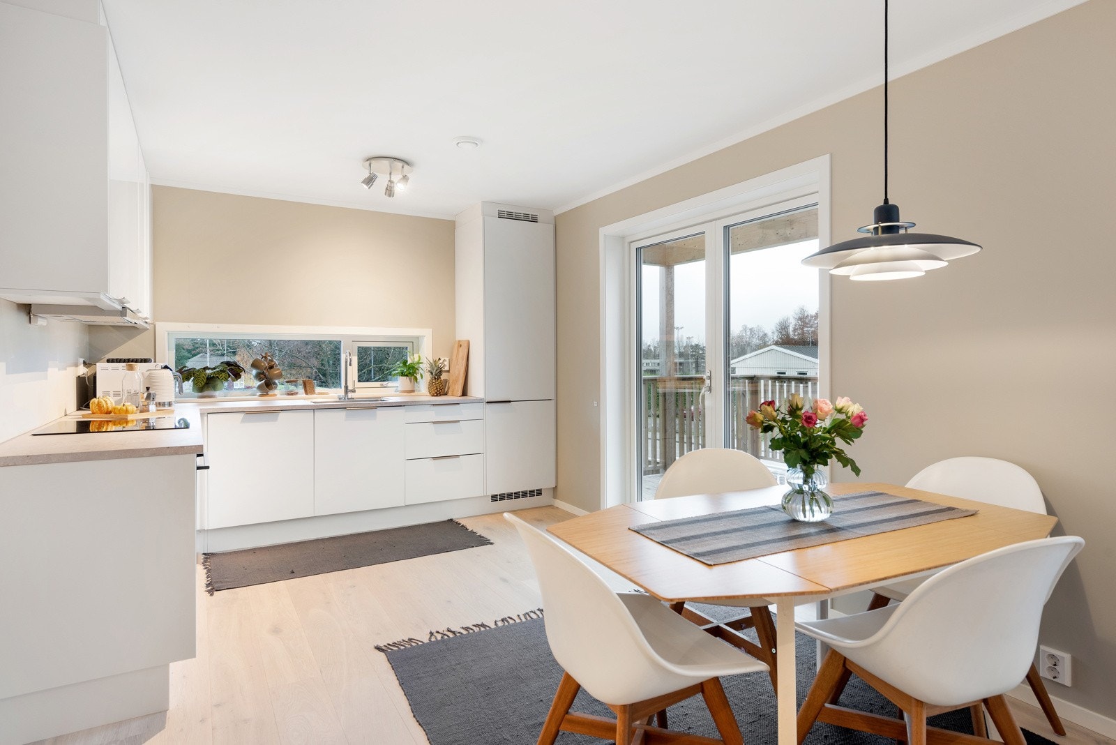 Over kjøkkenbenken er det et langsgående vindu og i front er det en dobbel glassdør ut til balkongen, perfekt om man vil ta med måltidene ut. Galleribilde