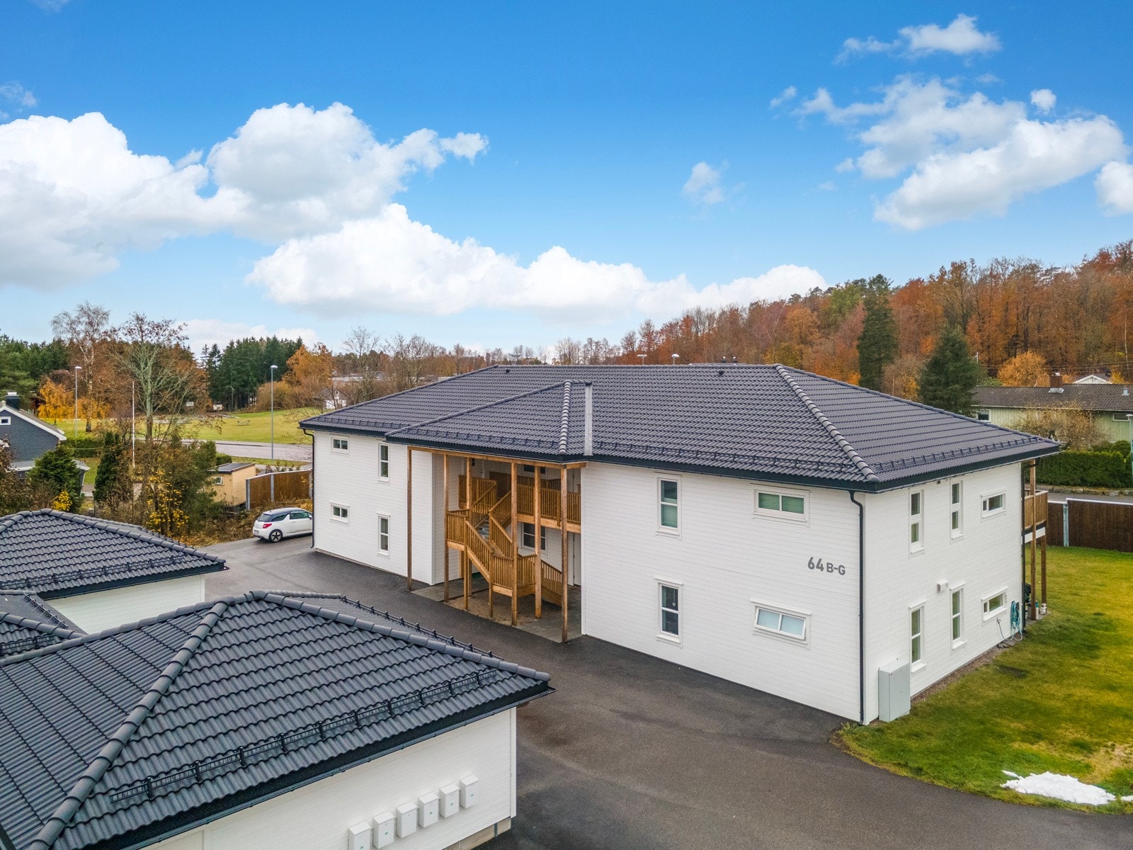 Fellesområdet er delvis inngjerdet og pent opparbeidet med store, grønne plener og asfaltert gårdsplass. Galleribilde