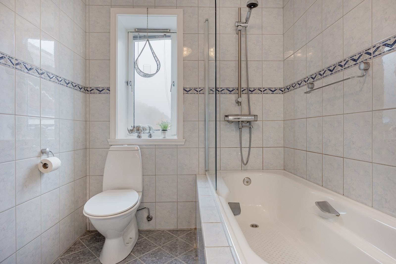 Badet er ellers innredet med innfliset badekar med glassnisje, toalett, dobbel servant med møblement, speil og belysning. Galleribilde