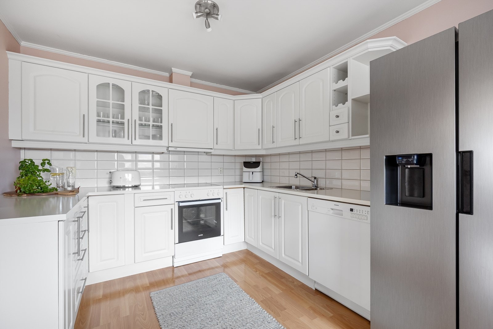 Her finner du en tidløs innredning med hvite profilerte fronter. Galleribilde