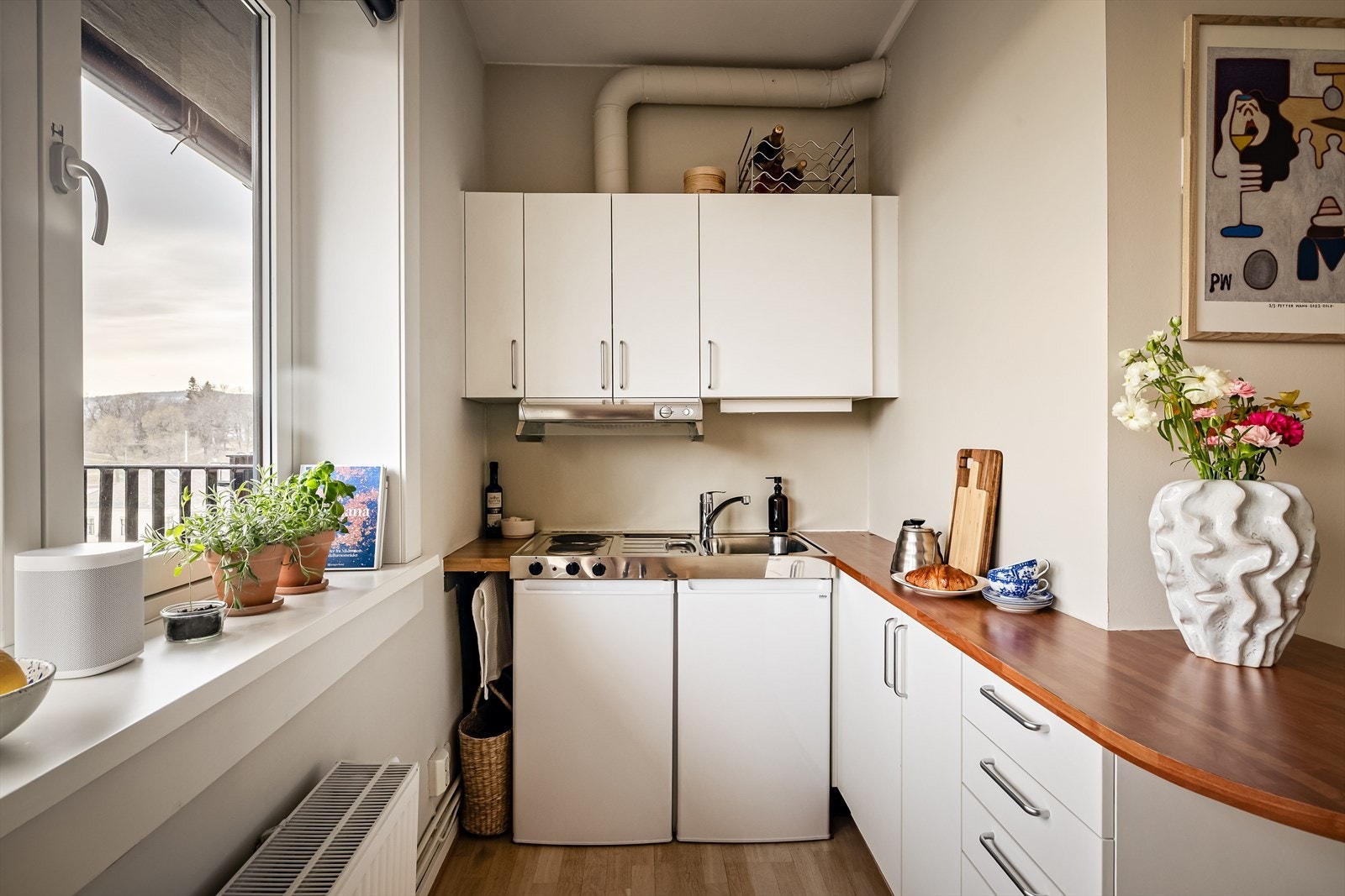 Lyst kjøkken med hybelkum med to stekeplater og kombiskap. Galleribilde