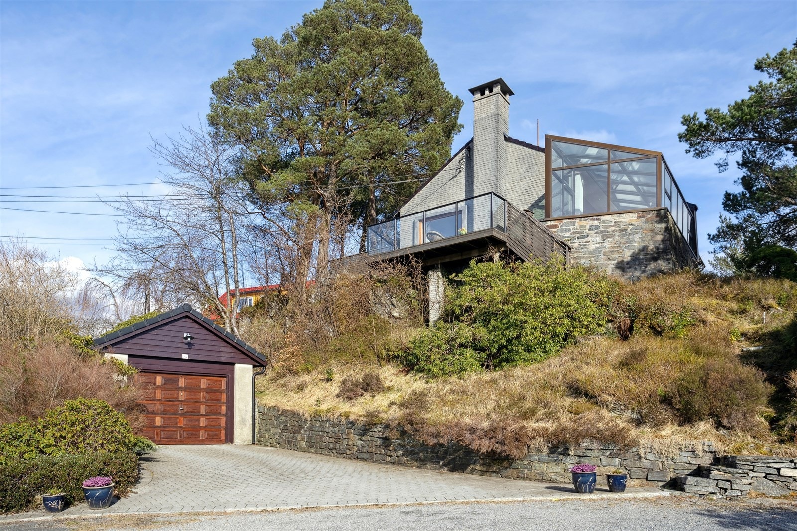 Fasade på huset fra nedsiden, den ene garasjen til venstre i bildet. Galleribilde