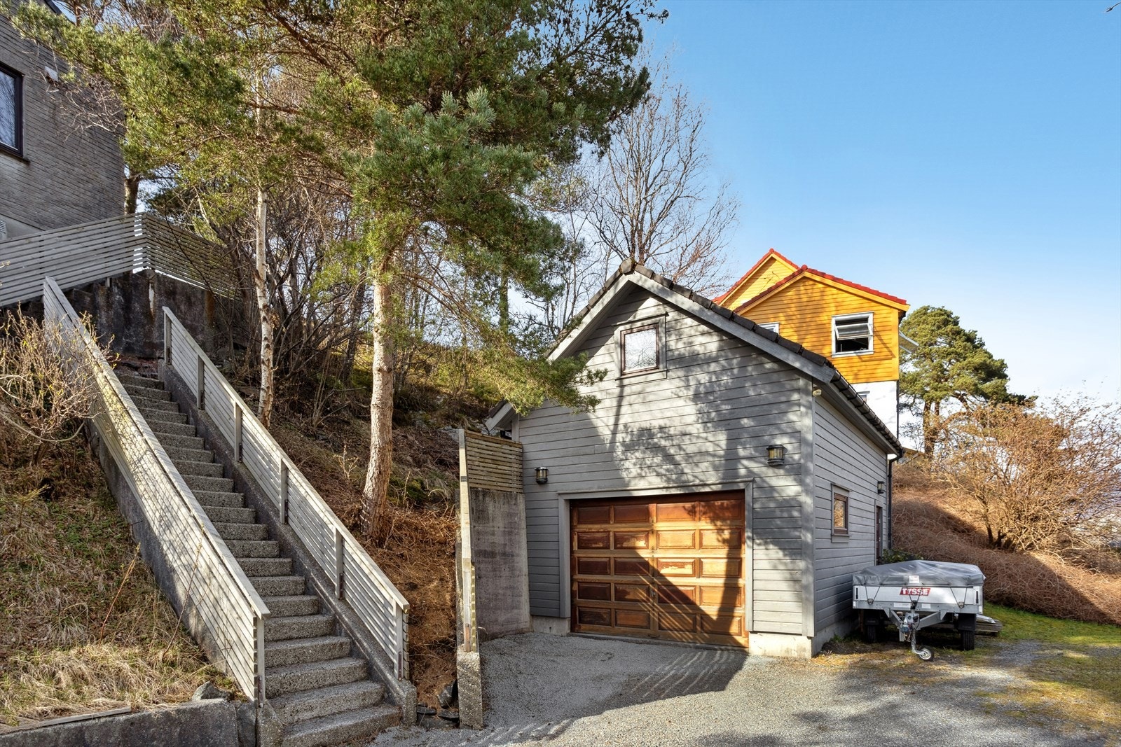 Det er to garasjer på eiendommen. Trapp opp til huset også fra denne siden. God lagring oppå garasjen. Galleribilde