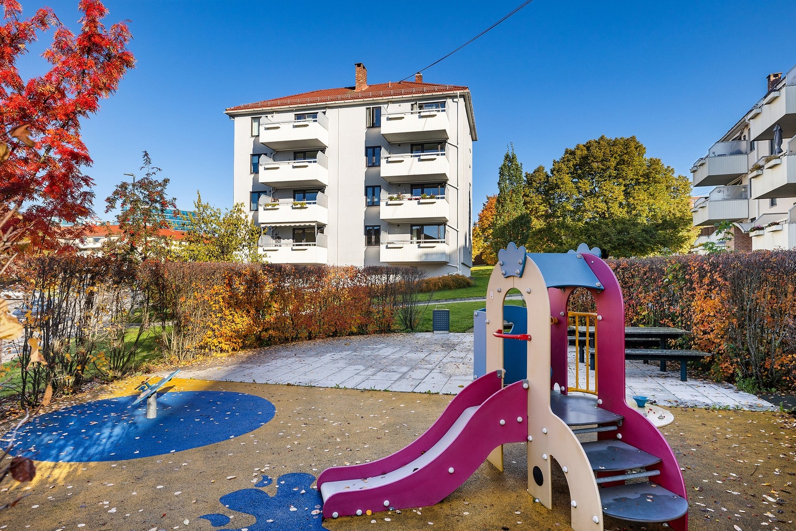 Pent opparbeidet med lekeplass, sittebenker og prydbusker Galleribilde