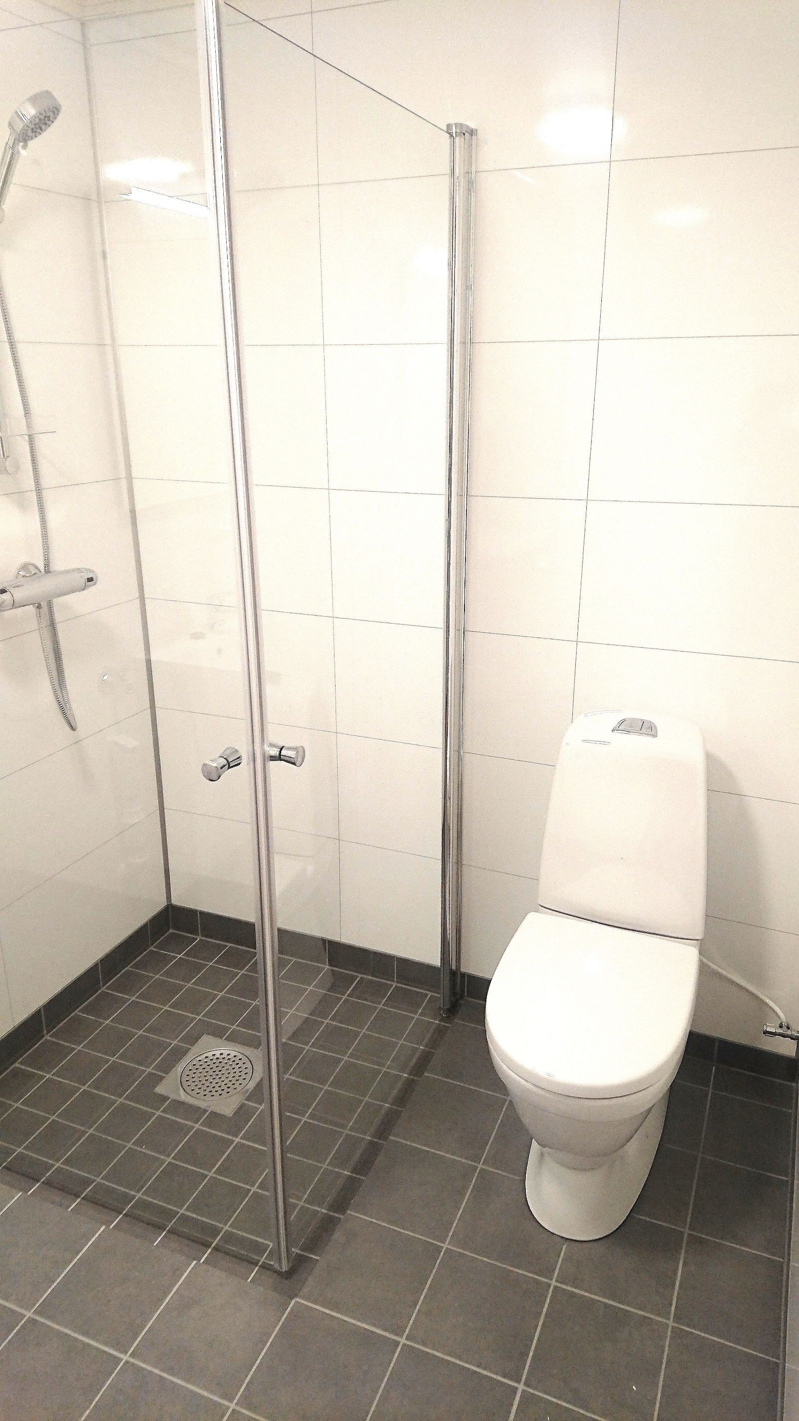 Badet har gulvvarme, dusjhjørne, toalett og servant med innredning. Galleribilde