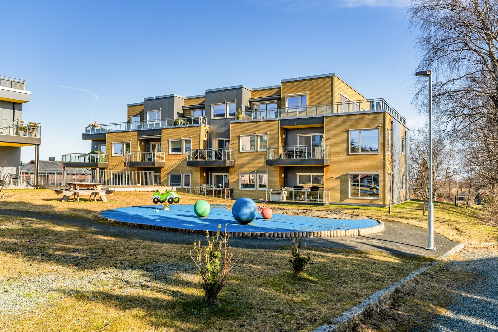 Fellesarealene på sommerstid er pent opparbeidede og sameiet har et eget område for gjesteparkeringer. Galleribilde