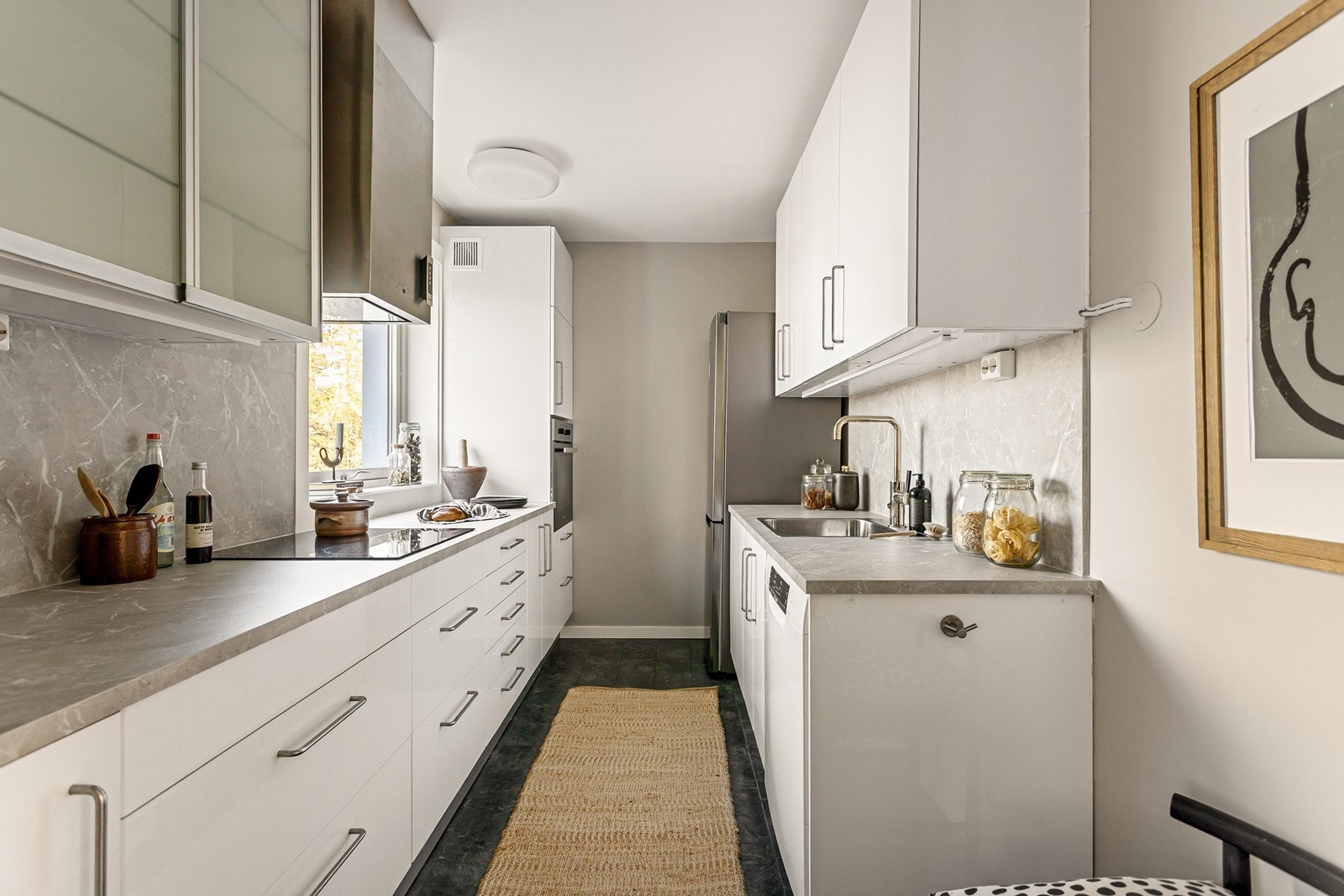 Praktisk kjøkken med masse skap og benkeplass, hyggelig utsikt mot rolige omgivelser. Galleribilde