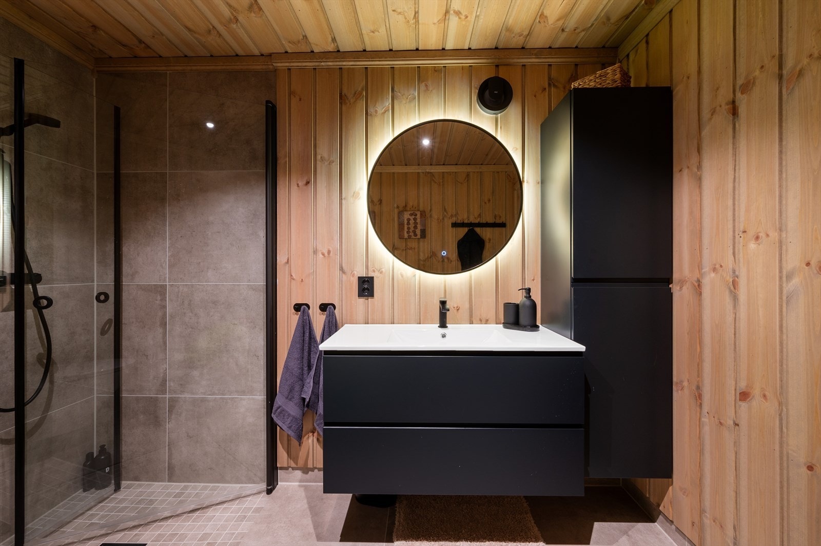 - Badet er innredet med benkeskap med servant, høyskap, dusjdører i glass og vegghengt toalett - Galleribilde