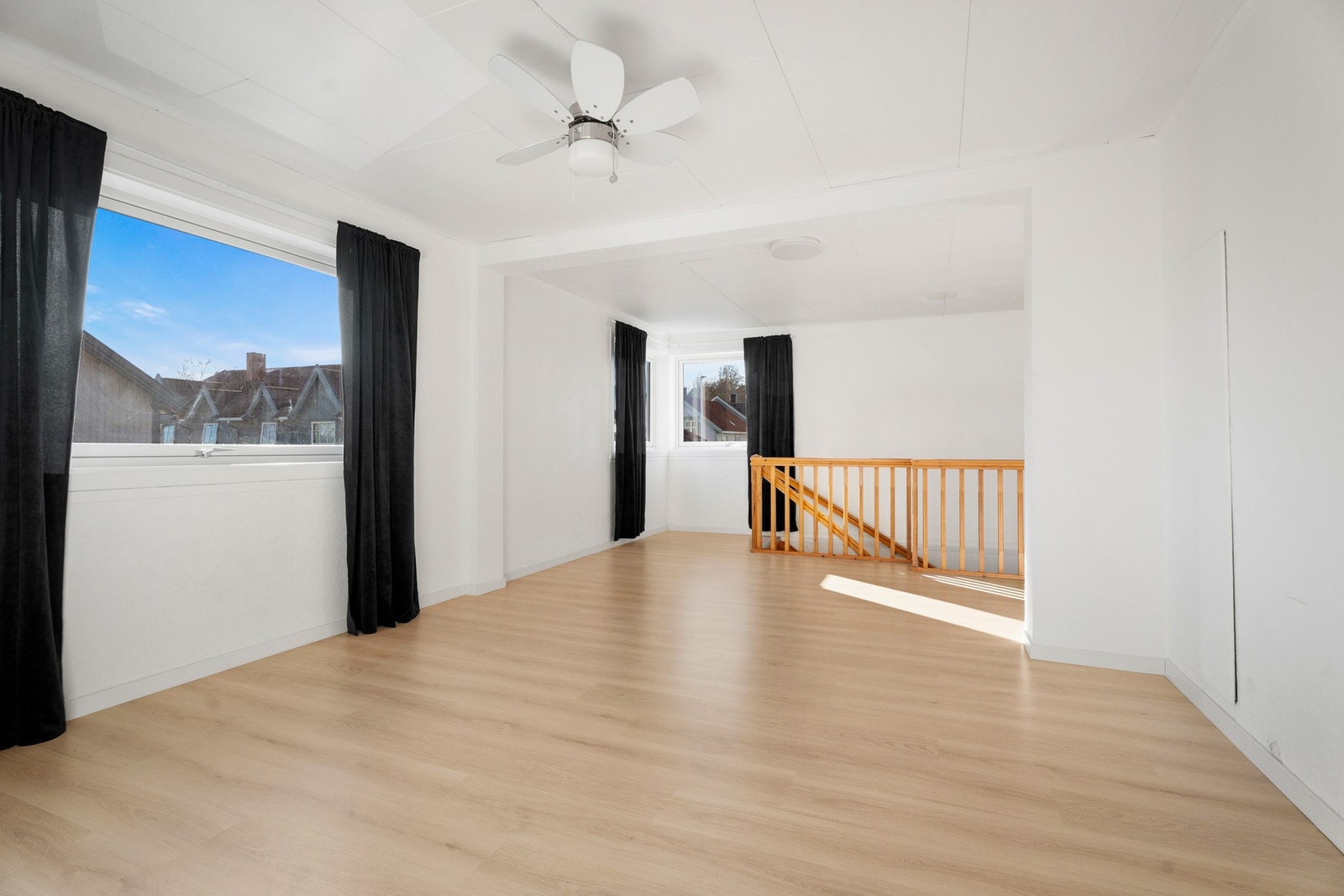 Her kan det innredes med sofagruppe, lenestoler og tv-/mediastasjon, og rommet har hvitmalte vegger mot lyst, pent laminatgulv. Galleribilde